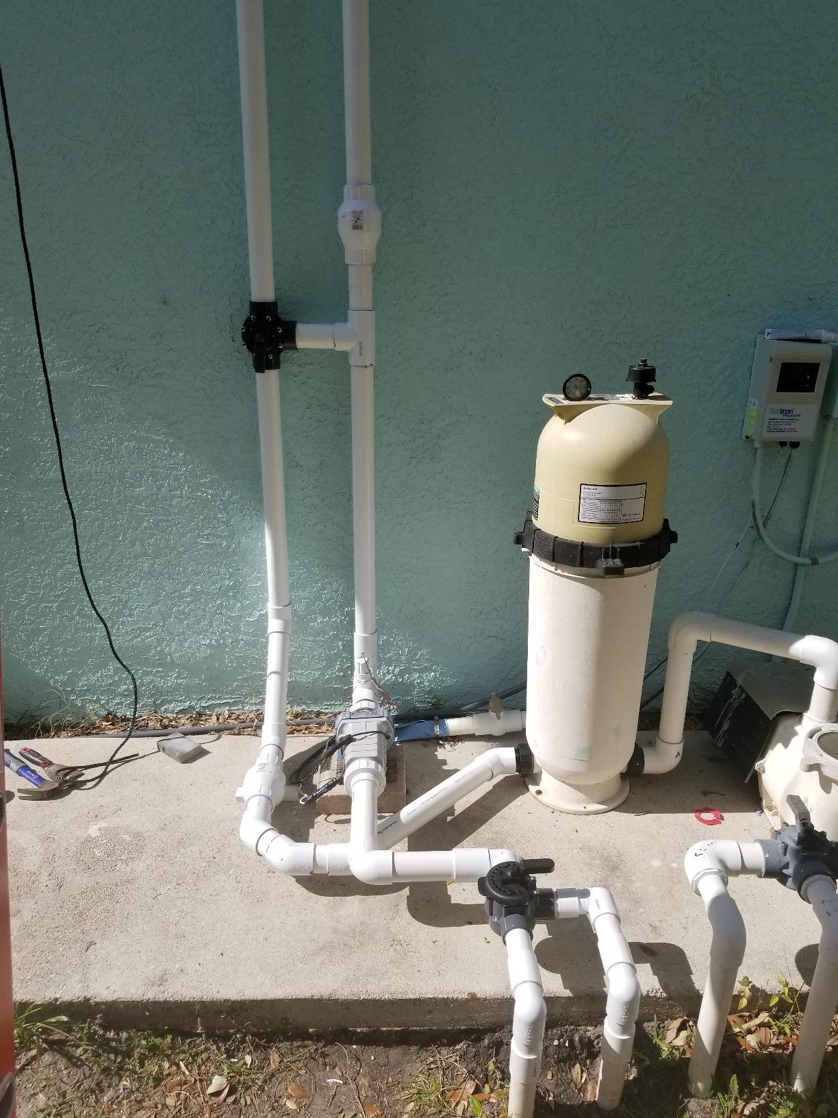 SunHeater S601P solar pool heater plumbing connected to a pool equipment pad with pump, filter, solar diverter valve, and rooftop solar collector supply and return lines.
