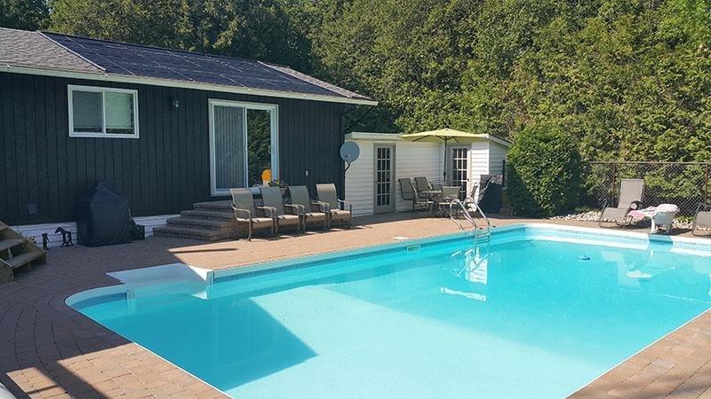 Roof-mounted DIY solar pool heater installation featuring SunHeater S601P solar collectors heating a swimming pool with free solar energy.